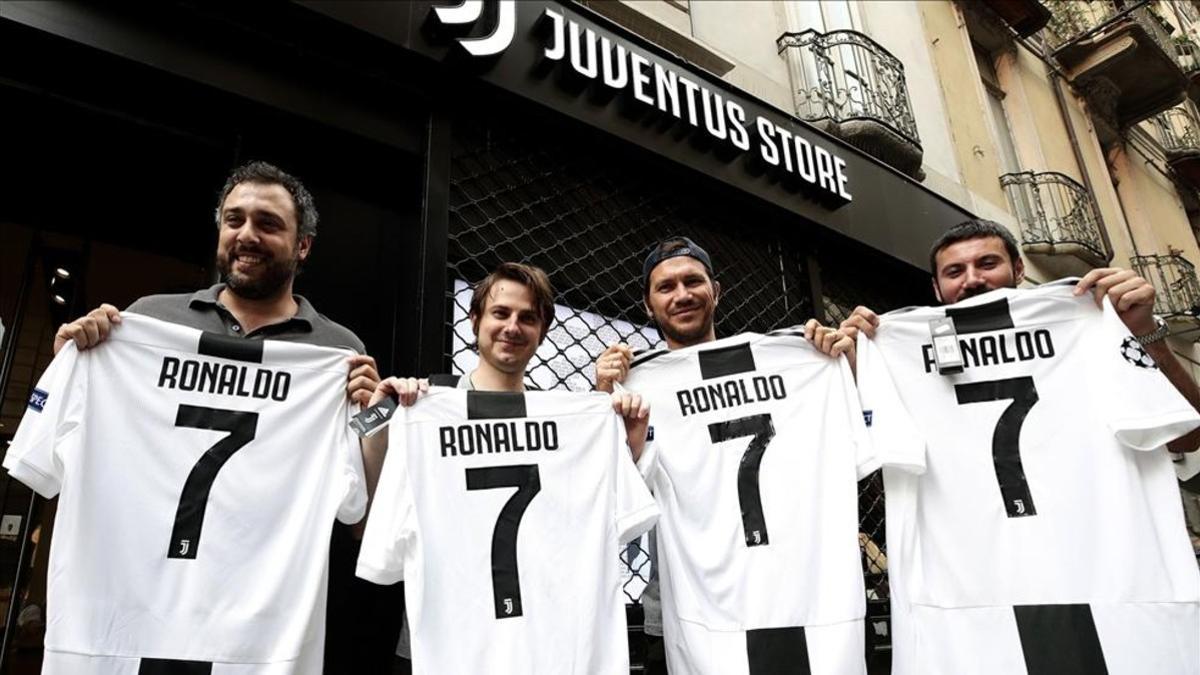 Aficionados de la Juventus posan felices con la camiseta de Cristiano Ronaldo