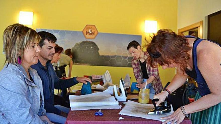 Los alumnos aprenden las técnicas de elaboración de telas enceradas durante el taller celebrado en el Centro de la Miel.