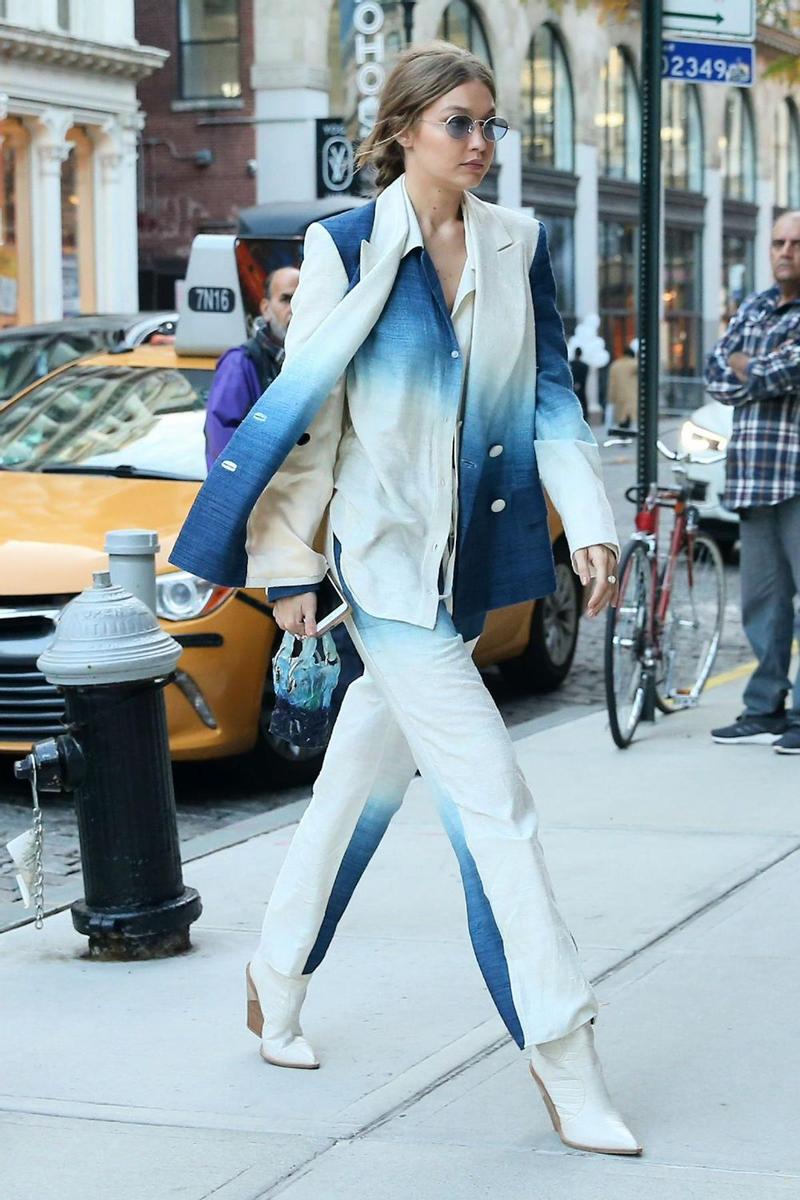 Gigi Hadid paseando por Nueva York con un traje con estampado tie dye acompañado de unas botas de estilo cowboy en color blanco