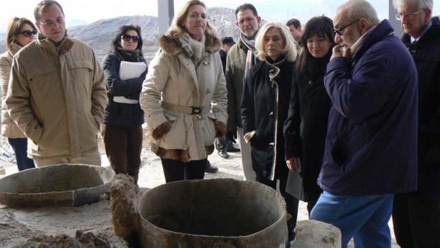 El director del yacimiento explica a la directora general y a la alcaldesa de Villena, entre otros, parte de los objetos del Cabezo Redondo.