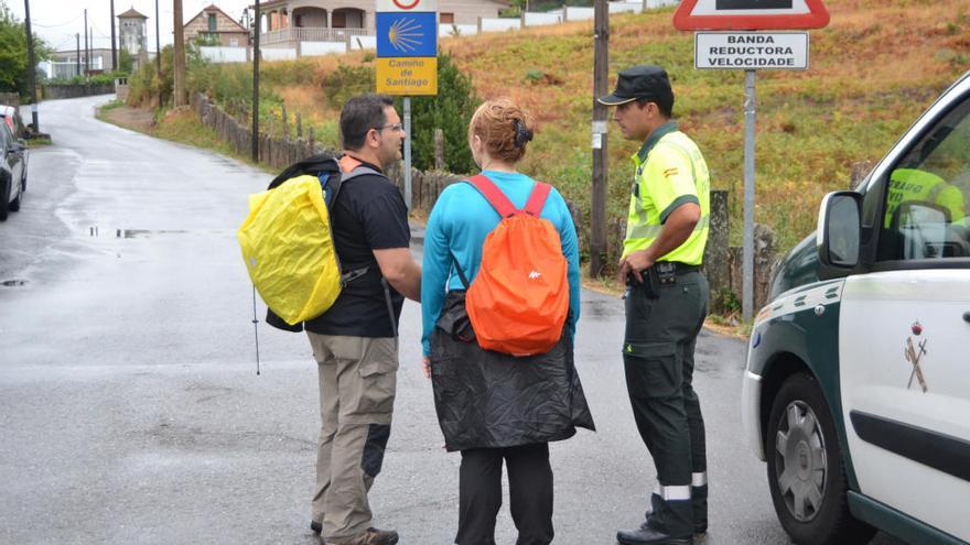 Un agente atiende a unos peregrinos