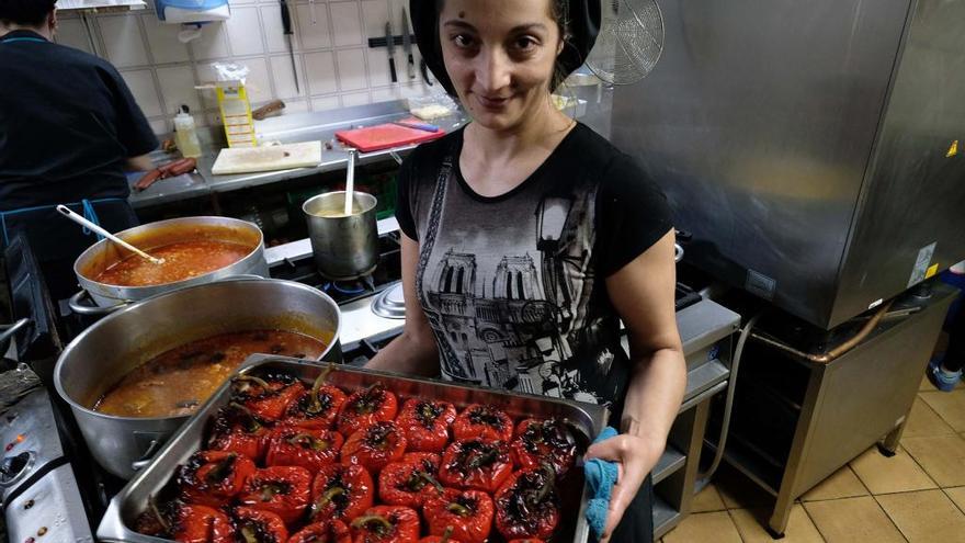 Una cocinera muestra una bandeja con pimientos rellenos en un restaurante de Blimea.