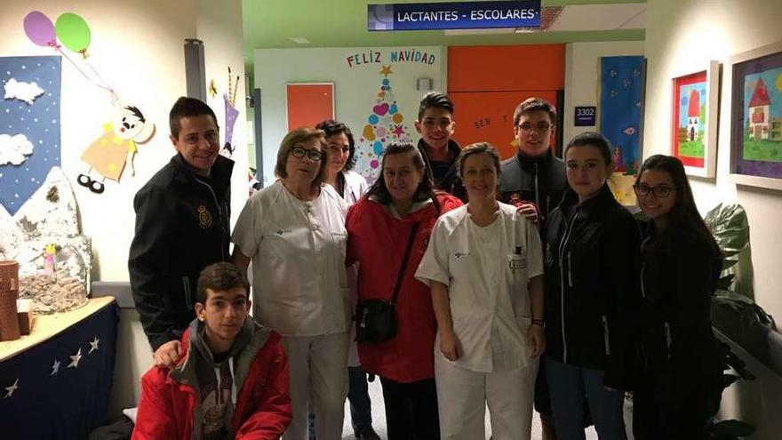 Miembros de la asociación posan con el personal del Hospital tras repartir regalos entre los niños.