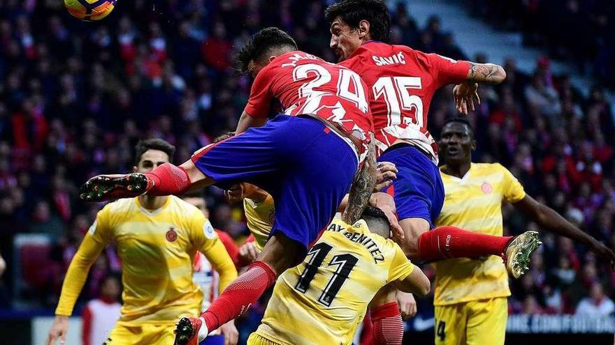 Savic y Giménez saltan ante los atacantes del Villarreal para despejar el balón.