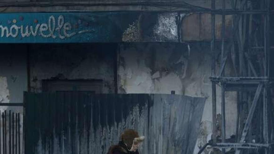 Una mujer camina sobre la nieve entre las barricadas de Kiev.  // Reuters