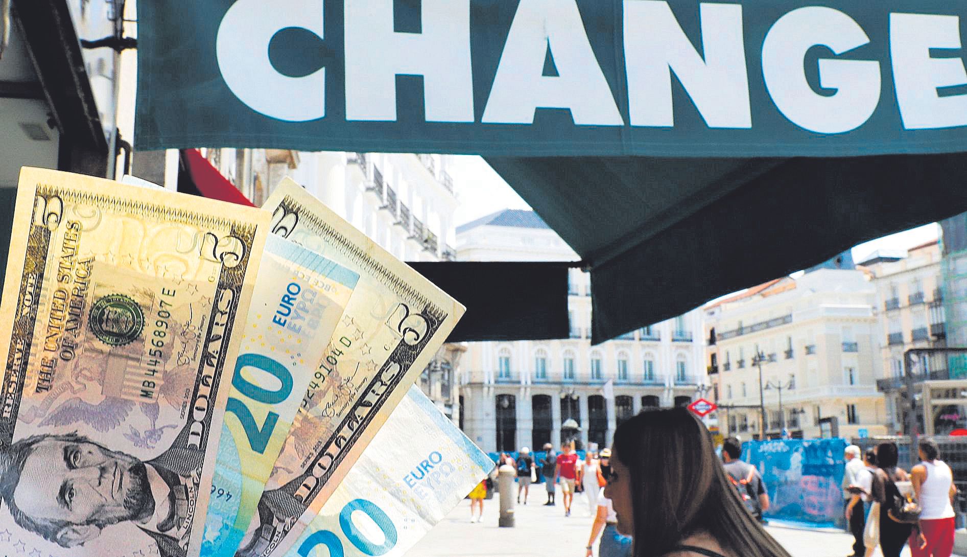 Publicidad con billetes de dólar y euro en una oficina de cambio de monedas