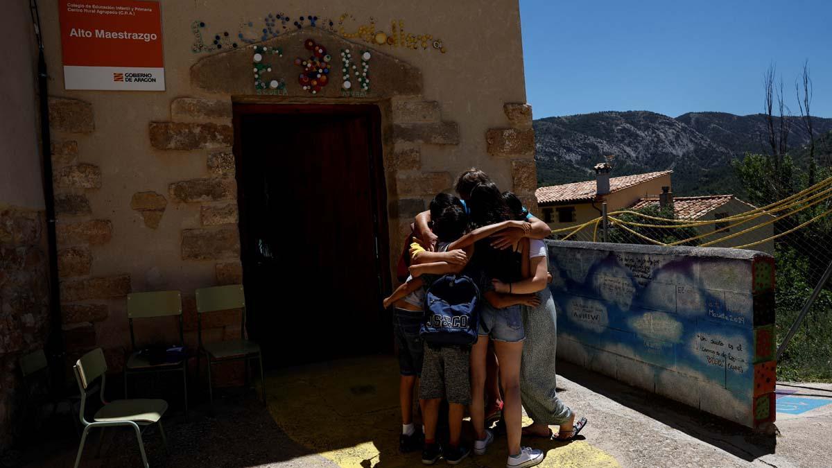 Alberto Toro, sus actuales alumnos y dos antiguos alumnos suyos que acudieron a despedirse, se funden en un abrazo el último día de clases en el pequeño pueblo español de Pitarque, Teruel, una de las regiones menos pobladas de la Unión Europea. Dos ex alumnos suyos asistieron al último día de clases junto a los últimos cuatro alumnos para despedirlo. “Cerrar la escuela va a ser negativo para el pueblo. Las escuelas son el motor del cambio y el desarrollo. Cuando las cierras, te estancas”, dice Toro.