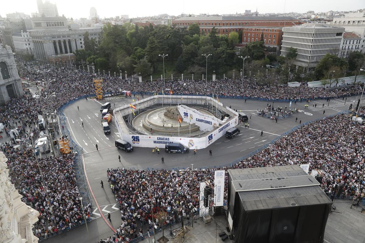 MADRID, 30/04/2022.- Aficionados del Real Madrid en la plaza de Cibeles de Madrid, esperan la llegada de los jugadores para celebrar el título de Liga conseguido por el equipo tras vencer al RCD Espanyol por 4-0, en el partido de Liga disputado este sábado en el estadio Santiago Bernabéu, en Madrid. EFE/JUAN CARLOS HIDALGO