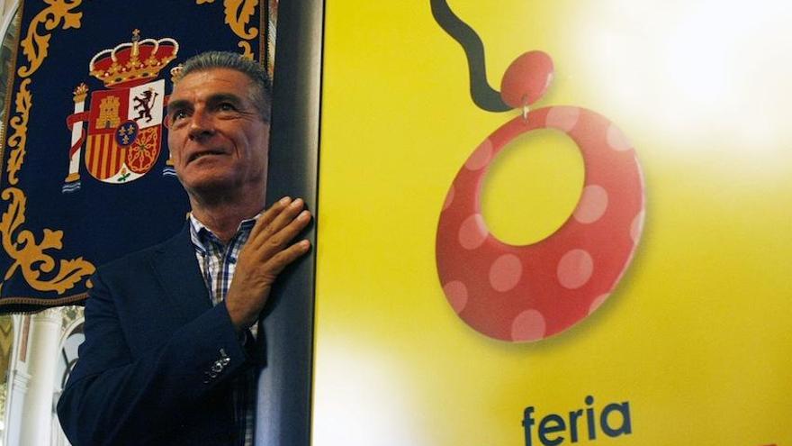 Manolo Sarria, junto al cartel de la Feria de 2014.