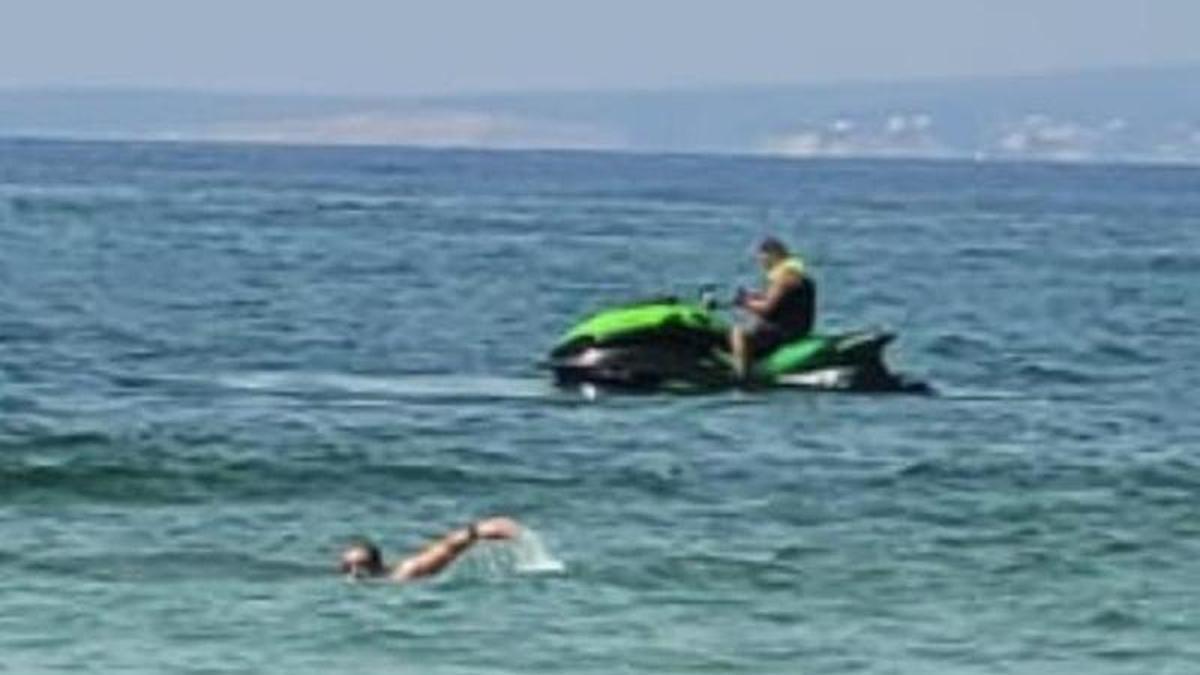 Los motoristas que conducen a escasos metros d elos bañistas en la playa de es Molinar.
