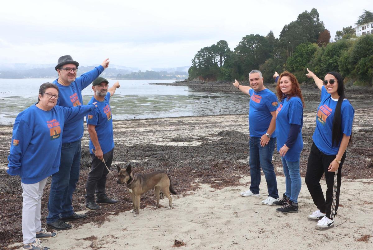 Integrantes de la asociación Veciños da Obra señalan desde la playa de Sada a la zona donde se ubican los restos del castillo de Corbeiroa.