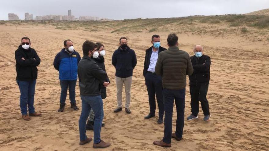 Los vecinos de El Altet protestando frente a la arena extraída de su playa, por la tarde. | ANTONIO AMORÓS