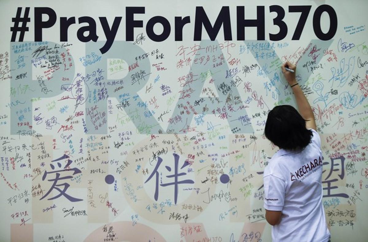 Una dona deixa un missatge en record dels passatgers del vol MH370 de Malaysia Airlines, a Kuala Lumpur.