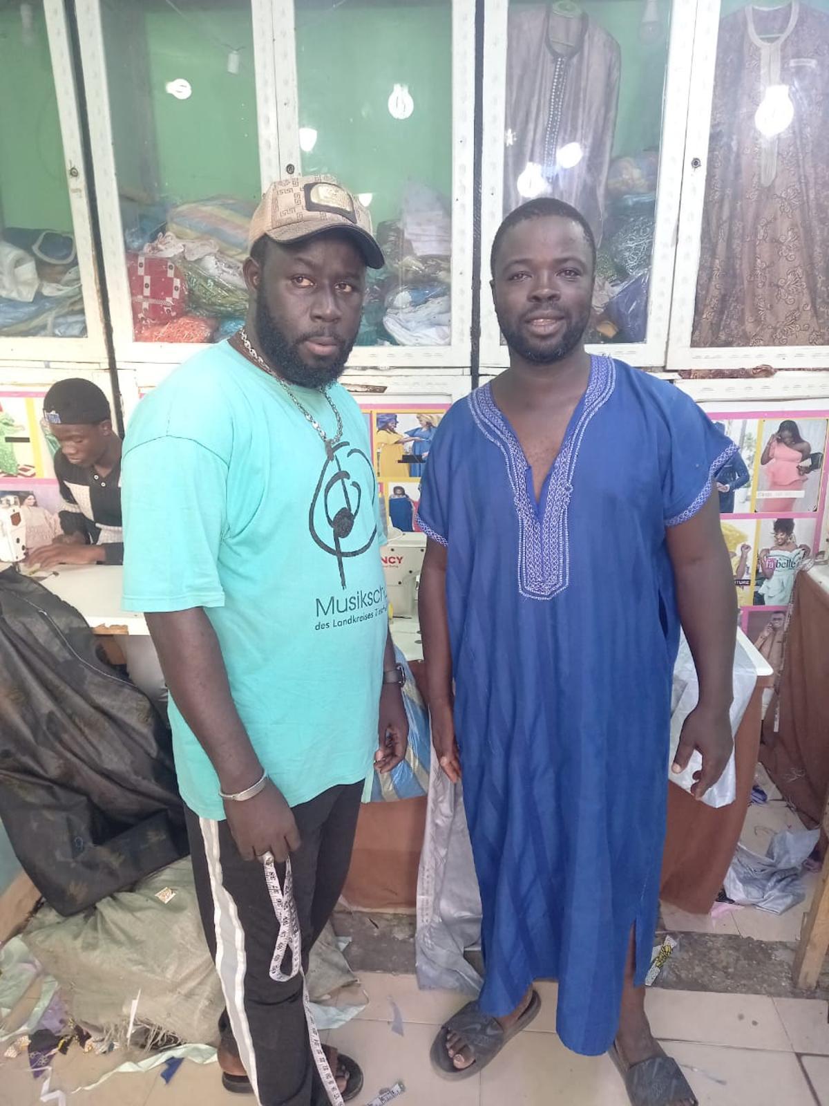 Hassane (dcha.) ayer con un amigo que tiene un taller de costura, en el barrio en donde reside en la capital Nouakchott.