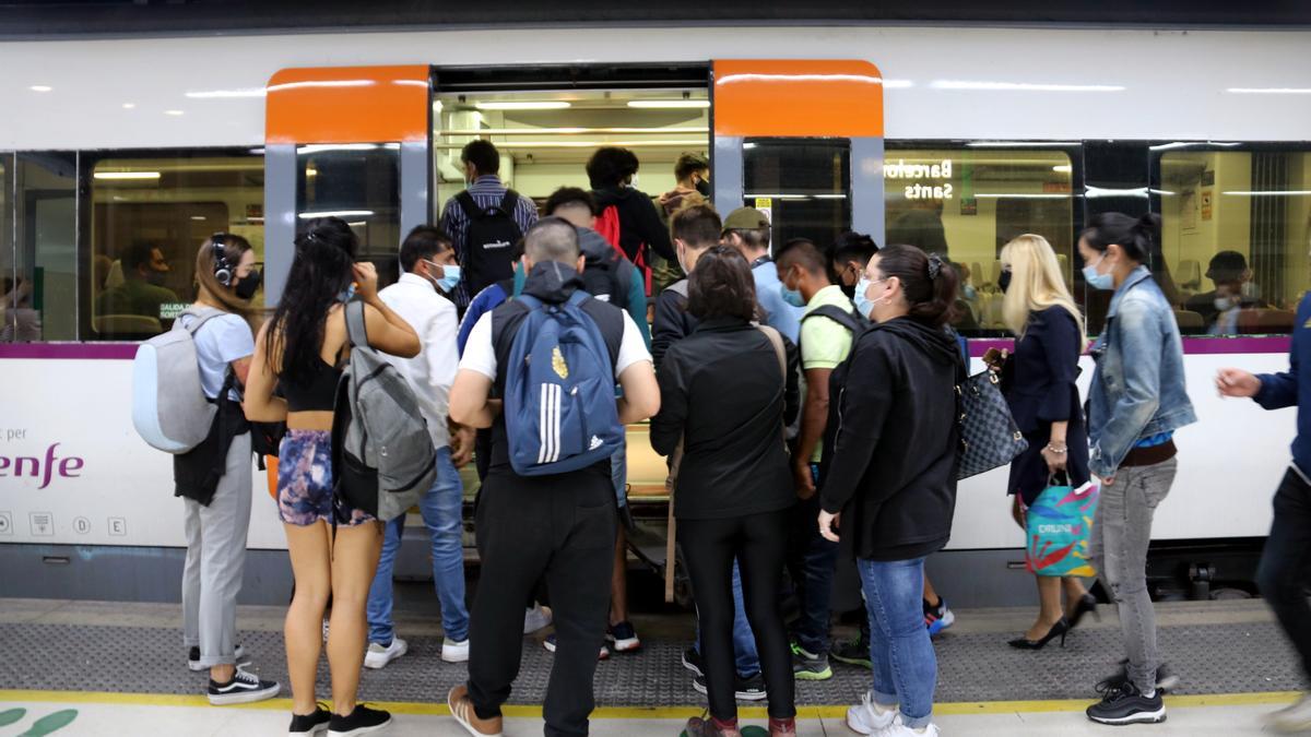 Un nombrós grup de gent intenta entrar a un tren en la segona jornada de vaga de maquinistes de Renfe a l'estació de Barcelona-Sants