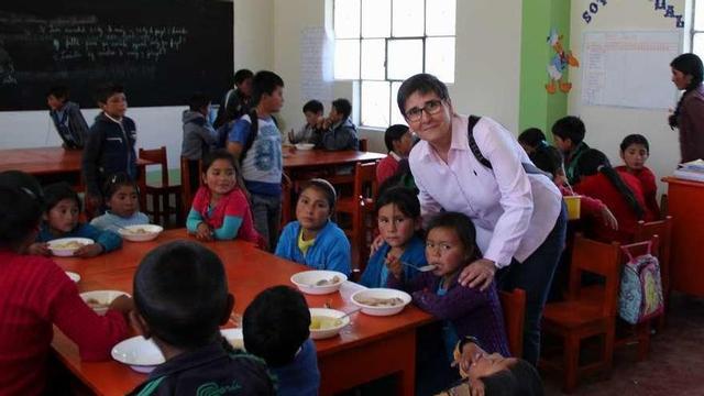 Pilar Muñoz, de Aulas abiertas, junto a menores que disfrutan de los servicios del comedor escolar. // FdV