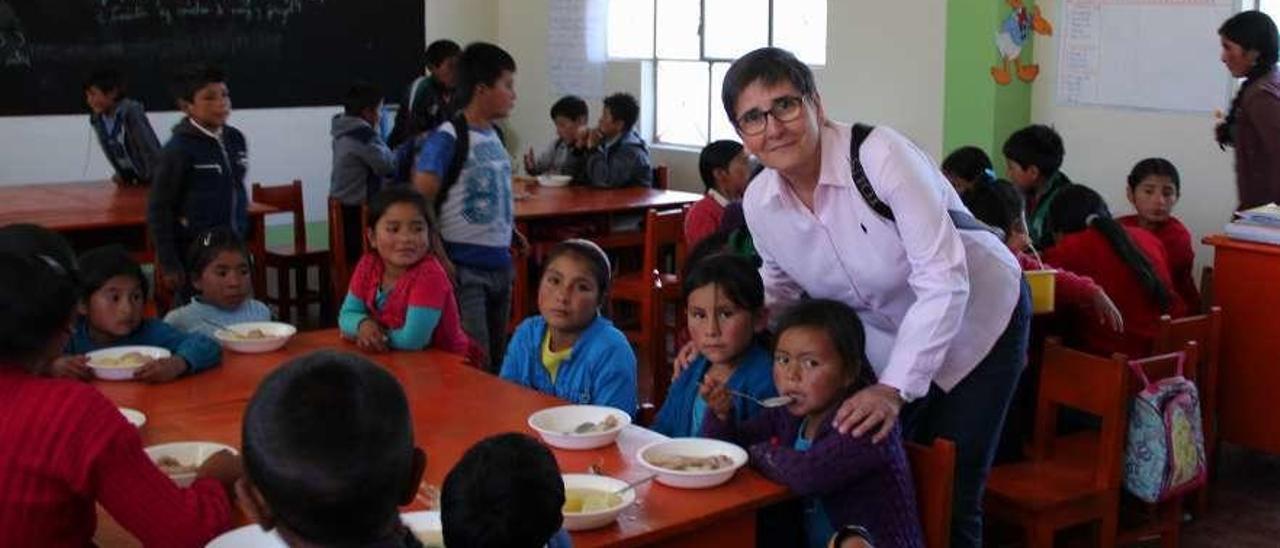 Pilar Muñoz, de Aulas abiertas, junto a menores que disfrutan de los servicios del comedor escolar. // FdV