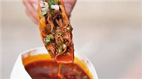 Taco de birria de Dos Coyotes que se moja en el caldo de birria