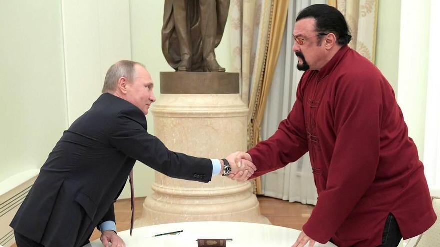 Putin estrecha la mano a Seagal tras entregarle el pasaporte.