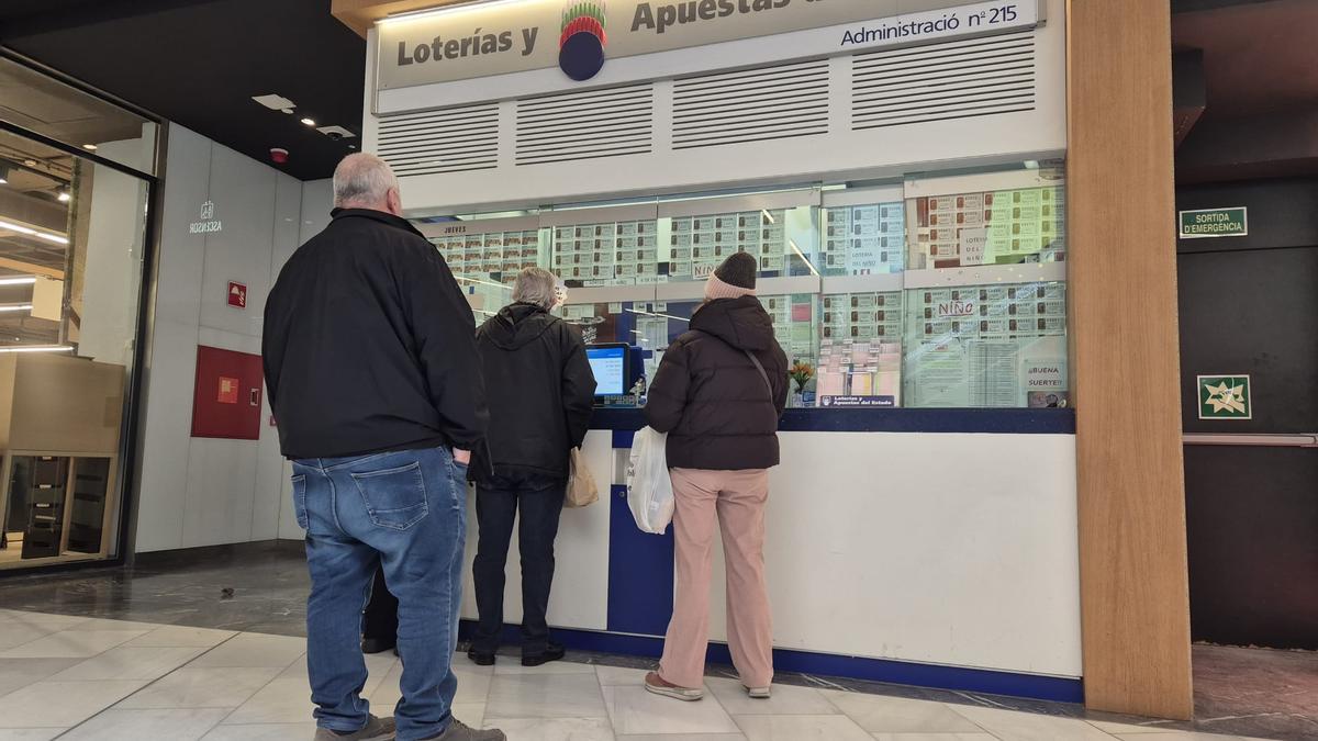 Clientes ante la administración de lotería de Glòries, que ha repartido 200.000 euros de un cuarto premio de Navidad, en Barcelona.