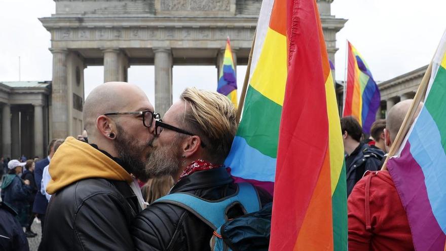 Una pareja se besa ante la Puerta de Brandeburgo.