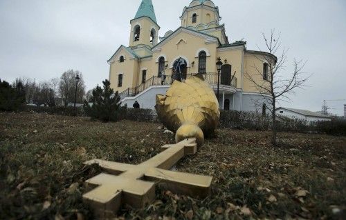 La cruz que corona esta iglesia ortodoxa se ve dañada en el suelo a causa de los bombardeos en Donest, al este de Ucrania, tres civiles murieron y ocho más resultaron herido durante los últimos bombardeos. 25 de noviembre de 2014.