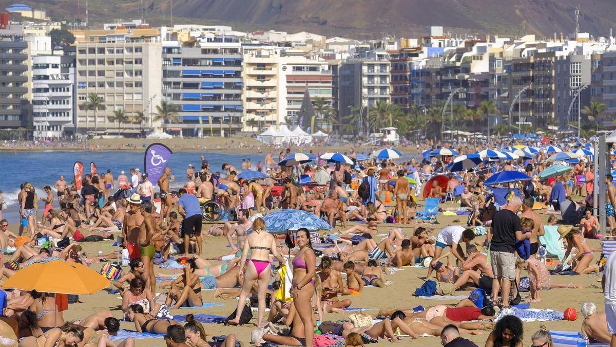 Turistas y residentes disfrutando de un día soleado en Las Canteras, en Las Palmas de Gran Canaria.