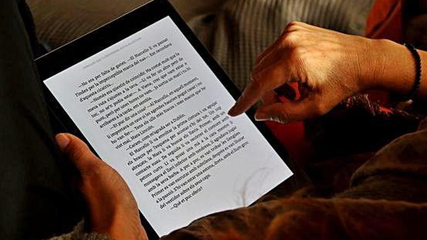 Una persona llegint un llibre en format digital.