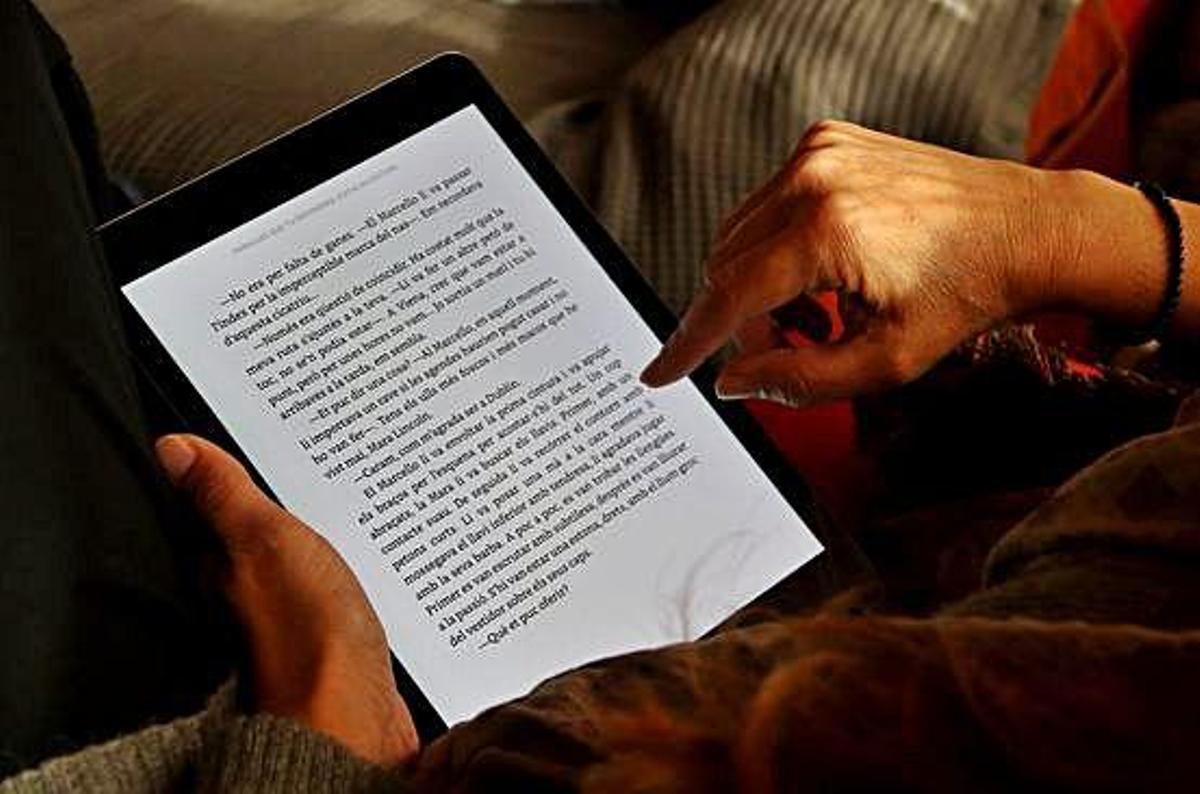 Una persona llegint un llibre en format digital.