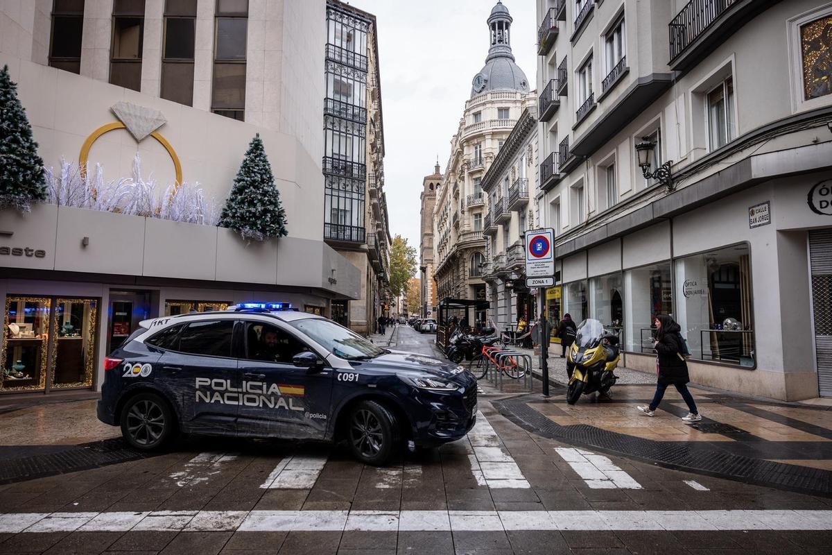 Un vehículo de la Policía Nacional, este jueves en la calle San Jorge de Zaragoza.