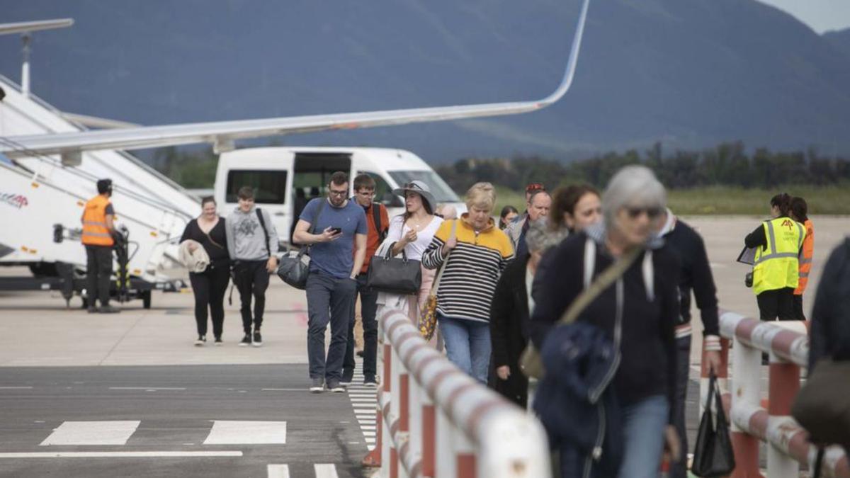 Turistes britànics baixant d’un avió de Jet2 a Vilobí.   | DAVID APARICIO