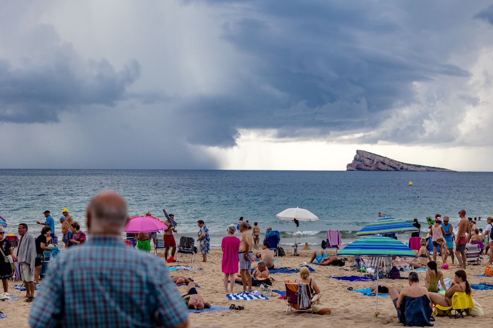 Los bañistas permanecen en las playas de Benidorm pese a la amenaza de lluvias