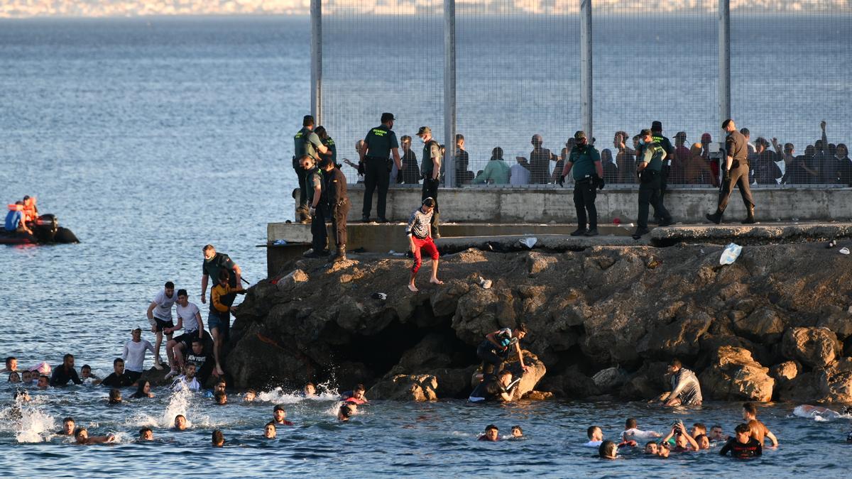 Personas migrantes en la playa del Tarajal, a 17 de mayo de 2021, en Ceuta (España). España ha movilizado al Ejército en la ciudad tras la entrada de más de 5.000 marroquíes en 24 horas.