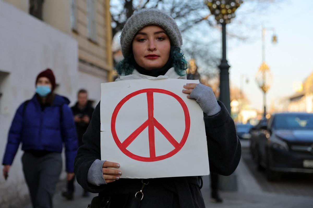 Una ciudadana moscovita protesta por la invasión con un símbolo de la paz.