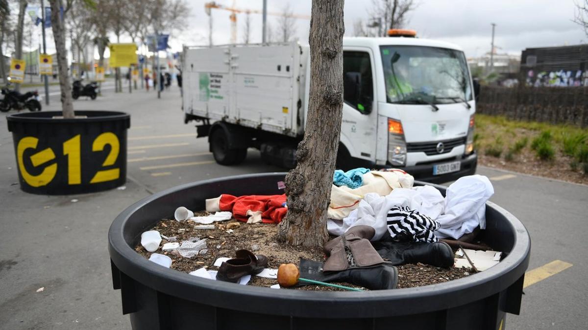 Operarios de limpieza retiran los restos del 'mercado de la miseria' que diariamente se instala junto al centro comercial Glòries