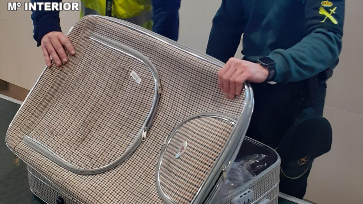 La Guardia Civil registra la maleta que contenía marihuana y hachís.