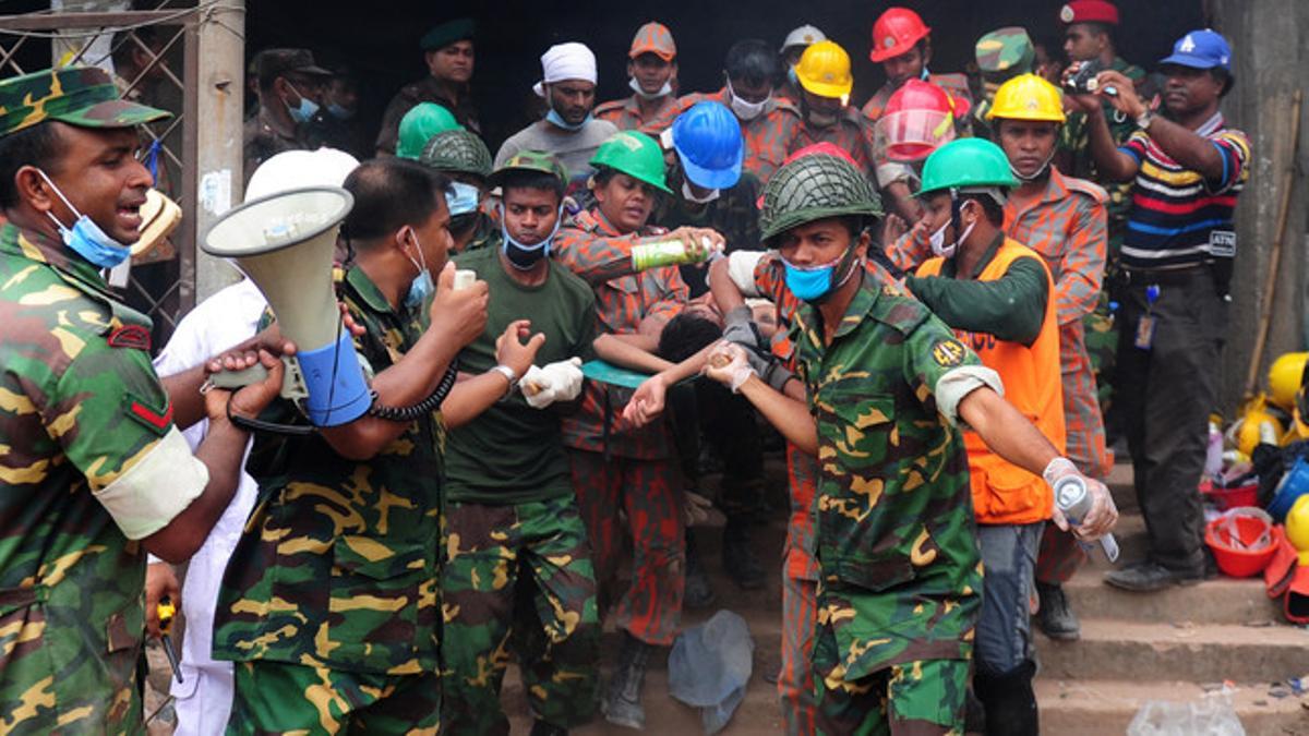 Equipos de rescate trasladan a un herido en el derrumbe de un edificio en Blangladés.