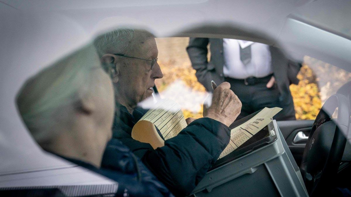 Una pareja vota desde dentro del coche para evitar contagios de covid en Copenhague.