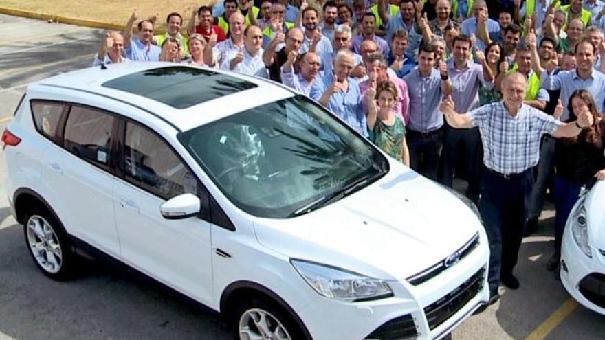 El director de Fabricación de Ford España, Antonio Adés, junto a un grupo de trabajadores de la planta de Almussafes, ante el modelo Kuga.