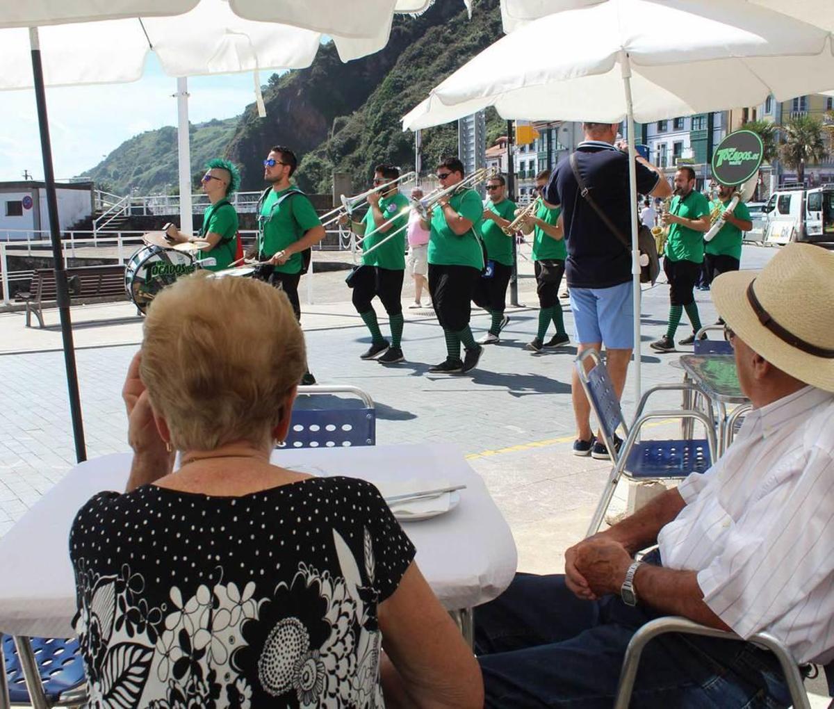 Una pareja, en primer término, contempla la actuación de "New Tocados" en el muelle candasín.
