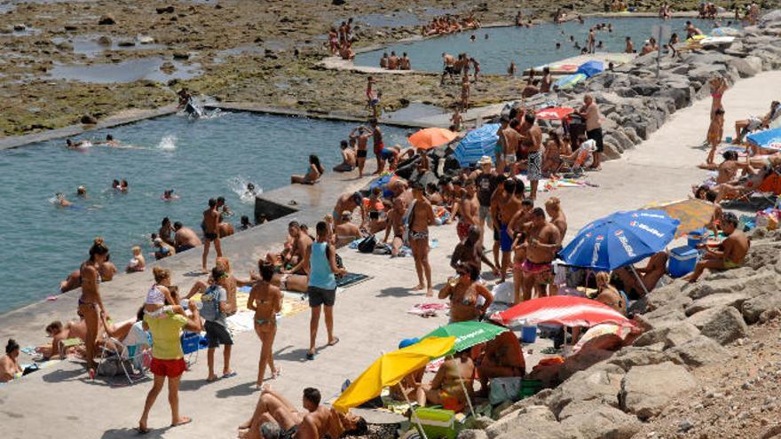 Multitud de bañistas disfrutando de las piscinas naturales de La Laja.