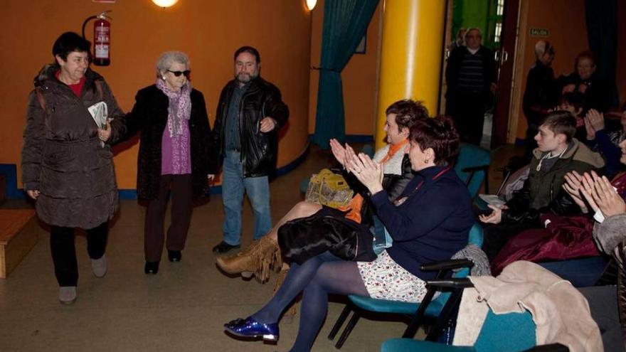 Celestina Marrón, de pie, en el centro, es aplaudida al entrar a la Casa de Cultura de La Felguera.