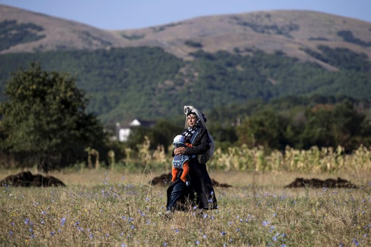 Un inmigrante sirio cruza un campo de cultivo en Serbia.