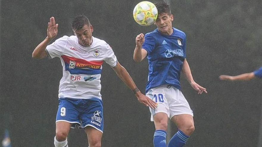 Riki cabecea el balón, con el jugador del Langreo Nierga a la izquierda, ayer en El Requexón.