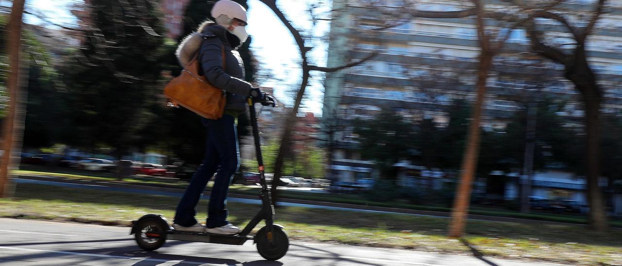 Una mujer circula en patinete eléctrico, hoy en València