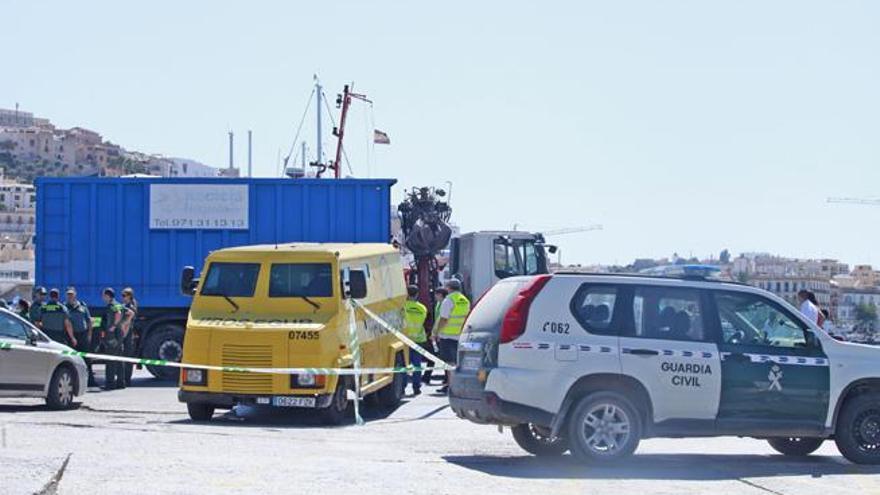 Un coche de la Guardia Civil junto al furgón blindado que intentaron robar en el ferry, el martes en el puerto de Vila.
