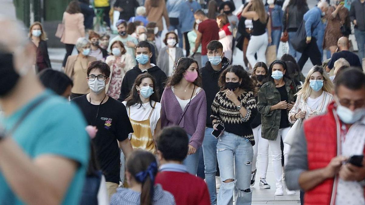 Viandantes paseando con mascarilla por la calle del Príncipe de Vigo.