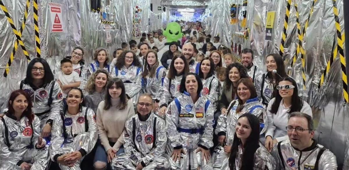 A la izquierda, alumnos y maestros en uno de los pasillos del centro transformados en un cohete espacial; a la derecha, la bandera del centro junto al Space Launch System. | L.O.