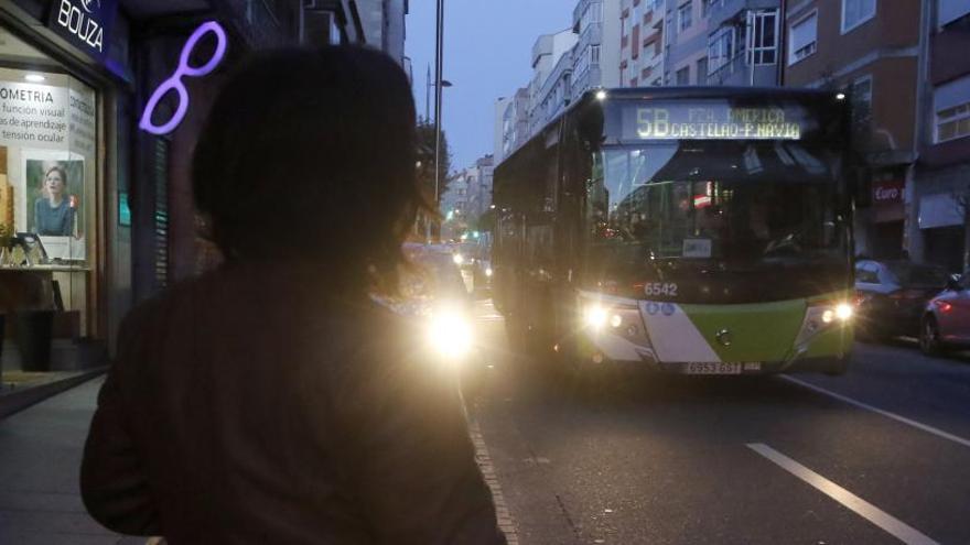 Una mujer espera al autobús en Vigo por la noche. / Alba Villar