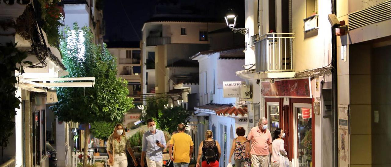 Vecinos pasean por una calle de San Pedro iluminada con dispositivos LED, de bajo consumo. | L.O.